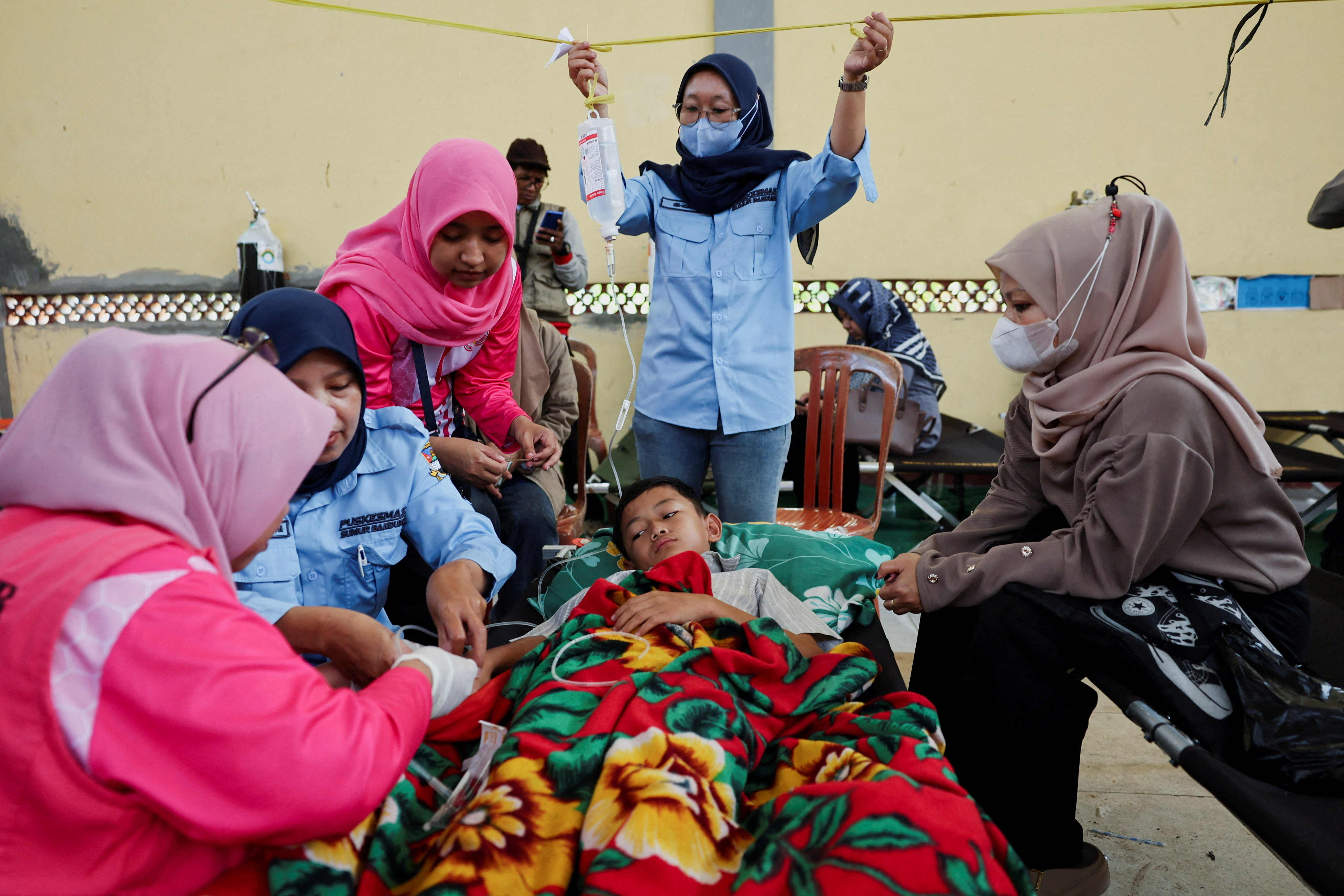 Muhammad Setiawan Pratama, 11, an elementary student receives treatment for food poisoning after eating government-sponsored free school meals, at a makeshift clinic inside a district's hall in Bandung, West Java province, Indonesia. (Reuters)